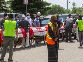 Caskets draped with Canadian flags are lined up at the Islamic Centre of Southwest Ontario in London, before Saturday's funeral for the four members of the Afzaal family who were struck and killed while out walking in a collision police allege was targeted attack because of their Muslim faith. Killed were Salman Afzaal, 46, his wife Madiha Salman, 44, daughter Yumna Salman, 15, and Afzaal's mother, Talat Afzaal, 74. (Mike Hensen/The London Free Press)