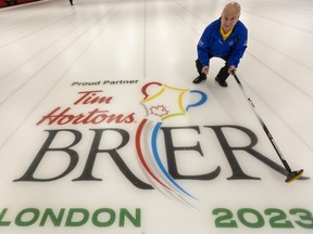 Peter Inch is a lead organizer with the 2023 Tim Hortons Brier curling event coming to Budweiser Gardens. He is shown with a logo at an associated rink at the St. Thomas Curling Club. Mike Hensen/The London Free Press