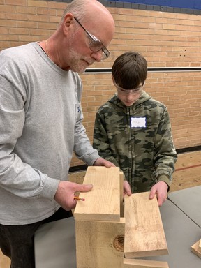 Ed Ellens and his son, Clay Ellens, worked together to prepare pieces of wood to be turned into a step-stool during a free inter-generational woodworking class hosted by the city on Saturday.