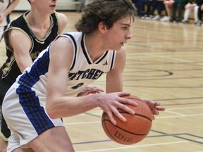 Jack Small of the Mitchell District high school senior boys basketball team dribbles out of trouble against this Holy Cross opponent during WOSSAA 'A' semi-final action Feb. 24 in Woodstock. The Blue Devils dropped a three-point decision, 52-49, but would rally for the bronze medal with a decisive win over London Westminster. CORY SMITH/POSTMEDIA