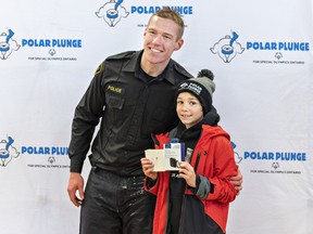 Brant OPP Const.  Jonathan Bueckert presented Jackson Baxter, age 9 with a pair of air buds and a case for being the top fund raiser at Polar Plunge 2023.