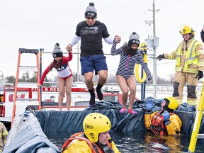 Brantford Police Const.  Melvin Monteblanca and his daughters Zoe (left) and Sophia leap into a bin of cold water on Saturday at the Brantford airport fire hall.  The Polar Plunge 2023 was a fundraiser for Special Olympics Ontario.