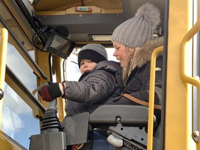 Asher Holtendorp, 3, and his mother Bailey Langlois were part of the crowds swarming the Paris Fire Hall on Dundas Street Saturday, Feb.  18 for both a chance to climb all over fire trucks and massive construction equipment and to show support for restaurant owner Scott Dammeier.  co-owner of Scott's Family Restaurant, who is undergoing treatment for stage four bladder cancer.  SUSAN GAMBLE PHOTO