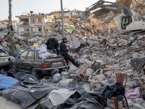 On Monday, people stand amid body bags and the rubble of collapsed buildings as they wait for news of their relatives in Hatay, Turkey's southern most province, hit hard by last week's earthquake.  The Muslim Association of Brantford has launched a local effort to get aid to quake victims.  BULENT KILIC/AFP via Getty Images