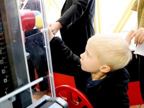 Three-year-old Weston Kloosterman places a plastic ball in an exhibit meant to illustrate the workings of the Port of Johnstown at the Aquatarium on Friday afternoon, as the facility celebrated the new exhibit. (RONALD ZAJAC/The Recorder and Times)
