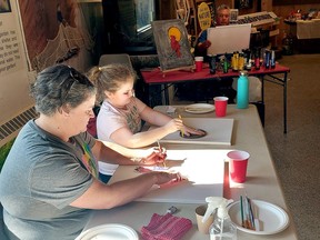 Jennifer Richmond and her daughter Jolene Wood, 9, get started on creating a winter bird theme painting on Saturday during an art workshop led by Indigenous artist John Williams, seen in back, during the Rondeau – Family Day Weekend – Cultural Celebration event.  PHOTOEllwood Shreve/Chatham Daily News.