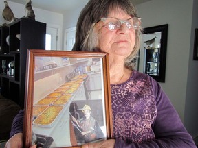Brenda Turcotte Laberge holds a photo of rows of lasagnas her late husband, Norm Laberge (inset) baked one year to raise money for a children?s Christmas charity in Goderich where the couple lived at the time. JEFFREY OUGLER/Postmedia