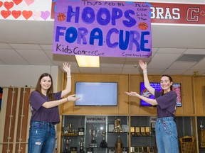 Hoops for a Cure organizers Brooklyn Veckenstedt, left, and Caitlyn Rost pose High School on Thursday, Feb. 9, 2023. Hoops for a Cure raised money for kids cancer research last week.