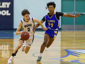 Bow Valley Bobcats Ethan Horb dribbles down court past Bert Church Chargers DJ Roberts at Bow Valley High School in Cochrane on Monday, Feb. 13, 2023.