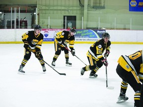 (L-R) Defenceman Terrell Vekved (2), forward Austin Cunningham (14) and forward Brody Beaulieu (19) line up for a draw in playoff action against the Morinville Kings, Feb. 5. (Supplied)