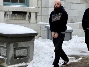 Brady Maher, 37, is led into the Frontenac County Court House by Kingston Police special constables on Thursday. Maher pleaded guilty to failing to provide the necessaries of life to his former partner Cara Cochrane in June 2020.