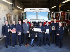 Steven Rogers of Enbridge Gas and Emily Folco of the Fire Marshal's Public Fire Safety Council present Kingston firefighters with a $5,000 donation to fund training and education materials for Kingston Fire and Rescue. On hand for the donation are, from left, Dep. Fire Chief Kevin Donaldson, firefighter Mike Botting, acting Capt. Matt Timmins, Chief Training Officer Richard Edworthy, firefighters Wesley Orobetz and Aiden Plouffe, and Dep. Chief Melanie Jones in Kingston, Ont., on Wednesday.