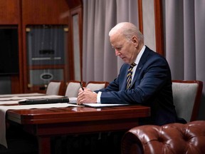 U.S. President Joe Biden sits on a train as he goes over his speech marking the one-year anniversary of the war in Ukraine after a surprise visit to meet with Ukrainian President Volodymyr Zelenskyy in Kyiv on Feb. 20, 2023.