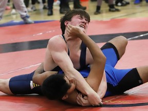 Foster Gilchrist, top, of Bishop Alexander Carter Gators, and Naman Aloria, of Lo-Ellen Knights, battle in a match at the high school wrestling finals at Ecole secondaire catholique l'Horizon in Val Caron, Ont. on Tuesday February 14, 2023. John Lappa/Sudbury Star/Postmedia Network