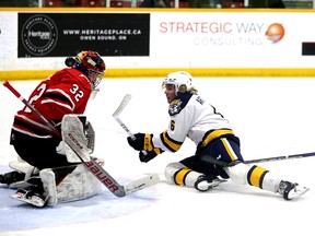 Taeo Artichuk gets a shot off on Carter George while falling to the ice as the Owen Sound Attack host the Erie Otters inside the Harry Lumley Bayshore Community Centre on Wednesday, Feb. 22, 2023. Greg Cowan/The Sun Times