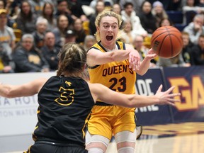 Queen’s Gaels' Bridget Mulholland, a graduate of Regiopolis-Notre Dame Panthers, passes past Waterloo Warriors' Kaitlyn Overeem in a 69-62 Ontario University Athletics women’s basketball semifinal win at the Queen’s Athletics and Recreation Centre on Wednesday, March 1, 2023.