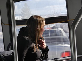 Woman looking out a bus window speaking into a radio