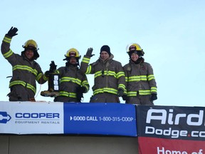 Airdrie firefighters wave to the opening ceremony audience after their first steps onto the roof of the Toad 'n' Turtle, where they spent 72 hours to raise awareness and funds for Muscular Dystrophy Canada.
