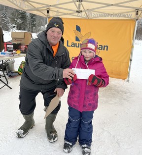 Molly Coulas caught the second longest fish of the day and is presented with her award by volunteer Rick Klatt.