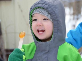 Two-and-a-half-year-old Finnian McCarthy enjoys some maple taffy during the Maple Magic event at Regal Point Elk Farm near Oxenden on Sunday, March 19, 2023.
