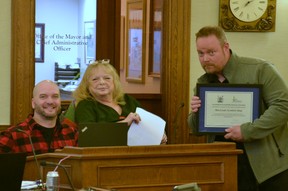 Stratford accessibility advisory committee chair Roger Koert and vice chair Diane Sims present Stratford's 2022 accessibility award to Rob Russell, owner of MacLeods Scottish Shop in downtown Stratford, at Monday's Stratford council meeting to recognize recent improvements made to his store.  Galen Simmons/The Beacon Herald/Postmedia Network