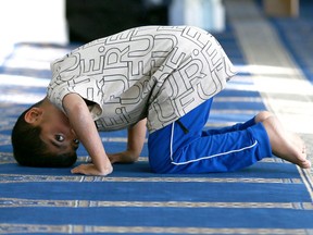 A young boy glances at a camera during prayers at the Green Dome Mosque in Calgary on Wednesday, March 22, 2023 to mark the start of Ramadan. The Islamic Supreme Council of Canada and Green Dome Masjid's Executive Committee will meet to see the moon for Ramadan the ninth month of Lunar for the Islamic Calendar. Jim Wells/Postmedia