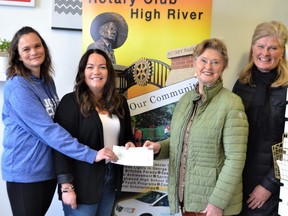 Marisa Blanchard, parent rep with Ecole Joe Clark, and Brianne Fredell, parent rep with Spitzee School, accept a cheque from Rotary Club of High River youth program coordinator Joanne Van Donzel. Dinah Van Donzel, director of Student Learning for the Foothills School Division, was also on hand.