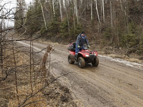 An off-highway vehicle rider drives along a road close to the Horse River near Abasand on Wednesday, April 5, 2017. Ian Kucerak/Postmedia