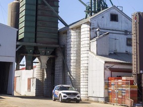 An Aylmer police vehicle sits near the silos at Elgin Feeds Ltd. on Wednesday, March 15, 2023, after the death of an 18-year-old who fell into a grain silo. (Mike Hensen/The London Free Press)