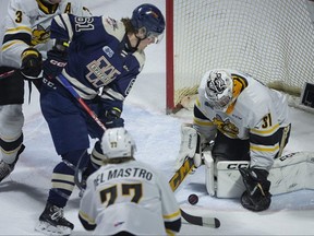 Windsor Spitfires' Colton Smith scrambles for the puck in front of Sarnia Sting goalie Nicholas Surzycia in OHL action at the WFCU Centre in Windsor, Ont., on Saturday, March 4, 2023.  (DAX MELMER/Postmedia Network)