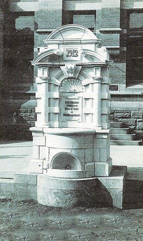 Designed by George W. Gouinlock in 1912, the Paris Old Boys' Foundation fountain belonged to all people who passed by.  It was not only an attractive monument but it was also utilitarian.  This water fountain supplied water to the horses walking along the road as can be seen at the front of it.  At the back was an opening closer to the sidewalk for smaller animals to get a drink and a higher one for the adults.  It was all encompassing.  The Paris Old Boys and Girls raised the funds for the fountain.  The Brantford Expositor photo