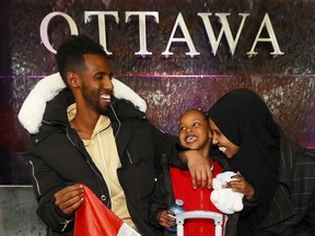 Nasro Adan Mohamed, a Somali refugee based in Brockville, has been trying since pre-pandemic to bring her husband and young daughter to Canada but they have been stuck in transit in Uganda. Nasro poses for a photo with her husband Liiban Ahmed Khadiye, and daughter Afnaan Liiban Ahmed at the Ottawa airport Wednesday. (TONY CALDWELL/Postmedia)