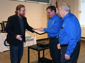Trevor Thompson, outgoing chair of the Lower Thames Valley Conservation Authority, left, presents Roger McRae, centre, and John Lawrence, right, from the Rotary Club of Chatham Sunrise the Volunteer Hero Award during the authority's annual general meeting held March 2, 2023. (Tom Morrison/Chatham This Week)