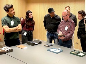 Huron University's Scott Schofield, second from right, discusses a rare book with Steven Cook, fourth from right, curator of the Josiah Henson Museum of African-Canadian History in Dresden, along with some Huron University students involved in the Freedom to Print project, while participating in a workshop on Chatham-related rare books hosted by the Eccles Centre for American Studies at the British Library. (Handout)
