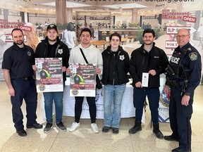 Cornwall Police Service Const. Patrick Huygen (left) and Sgt. Scott Coulter (right) at the CPS Fraud Prevention Month booth at Cornwall Square, and getting some support from St. Lawrence College police foundations students (from left) Austin Lauzon, Joseph Henshaw, Vanessa McRae and Chad Sicard. Photo on Tuesday,  March 21, 2023, in Cornwall, Ont. Todd Hambleton/Cornwall Standard-Freeholder/Postmedia Network