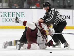 Linesman Justin Noble tries to break up a wrestling match between Kingston Frontenacs' Cal Uens and Peterborough Petes' Brennan Othmann in Ontario Hockey League action at the Leon's Centre on Friday, March 10, 2023. Uens received a five-minute fighting penalty on the play.