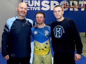 Ukrainian wrestler Volodymyr Burukov, middle, with Kingston Wrestling Club coach Marcus Niemann, left, and wrestler Connor Quinton at the club's BGC South East location on Bath Road in Kingston on Monday.