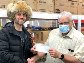 Photo by ANDREA PURYCH
Mitch Landriault, Elliot Lake Fur Harvesters treasurer, presents a $200 cheque to Ray Rochon, Elliot Lake Emergency Food Bank treasurer on March 13.