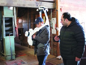 A student from Calgary's Southern Alberta Institute of Technology uses a digital mapping device at Nanton's orange elevator.