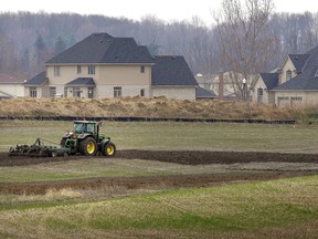 A farmer cultivates a field in southern Ontario.