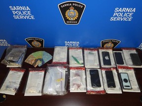 This photo provided by Sarnia police shows drugs, cash and other items allegedly found during a search of a home on Savoy Street.