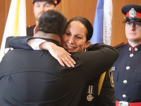 Sarnia police Deputy Chief Julie Craddock, a member of Beausoleil First Nation hugs Chris Plain, chief of the Aamjiwnaang First Nation, after her swearing-in at Sarnia city hall Monday.