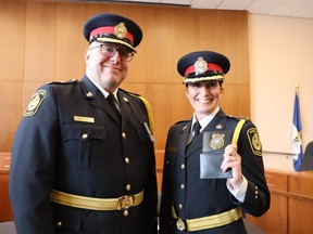 Sarnia police Chief Derek Davis celebrates with newly sworn Deputy Chief Julie Craddock, holding up her newv badge, at a ceremony in council chambers at Sarnia City Hall Monday.