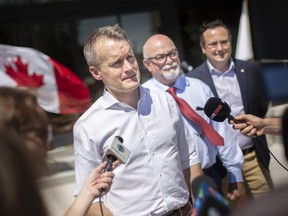 Labour Minister Seamus O'Regan is joined by Tecumseh Mayor, Gary McNamara, and Windsor-Tecumseh MP, Irek Kusmierczyk, as he speaks with the media in July during a vehicle charging infrastructure announcement outside Tecumseh Town Hall.