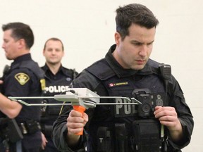 OPP Const. Alan Chronopoulos demonstrates Project Lifesaver technology in Sarnia Tuesday. Sarnia police, Lambton OPP and Victim Services Sarnia-Lambton are encouraging people to register loved ones at risk of wandering and going missing. (Tyler Kula/ The Observer)
