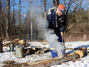 Melissa Levi, a St. Clair Region Conservation Authority education co-ordinator, demonstrates an early syrup-making technique during the maple syrup festival at A.W. Campbell Conservation Area in Alvinston Sunday. (Terry Bridge/Sarnia Observer)