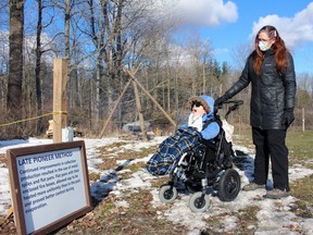 Aiden Welsh, 7, from Sarnia and respite worker Rebecca St. Pierre-Foster, from Oil Springs, check out an early method of producing maple syrup during Sunday's maple syrup festival at the AW Campbell Conservation Area.  Terry Bridge/Sarnia Observer/Postmedia Network