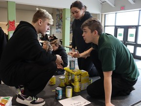 Competing in a contest to make a sculpture from food containers at St. Patrick's Catholic high school are, from left, Ahken Conway, Jewel Broadfoot and Alex Majeski.  It was part of an event held in the school's cafeteria to recruit volunteers for Saturday's Cyclone Aid community good drive.