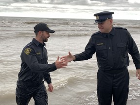 Norfolk Const.  Jeremy Renton, left, an organizer of Saturday's Polar Plunge for Special Olympics, was congratulated as he exited the chilly waters of Lake Erie at Turkey Point on Saturday, March 25 by OPP spokesperson Const.  Ed Sanchuck.  SUSAN GAMBLE/Brantford Expositor