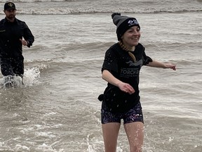 Special Olympian Taylor Bennett entered the chilly waters of Lake Erie at Turkey Point for the Polar Plunge Saturday, March 25 with organizer Norfolk OPP Const.  Jeremy Renton but she was quick to leave him behind and head back to dry land and a warm towel.  SUSAN GAMBLE/Brantford Expositor